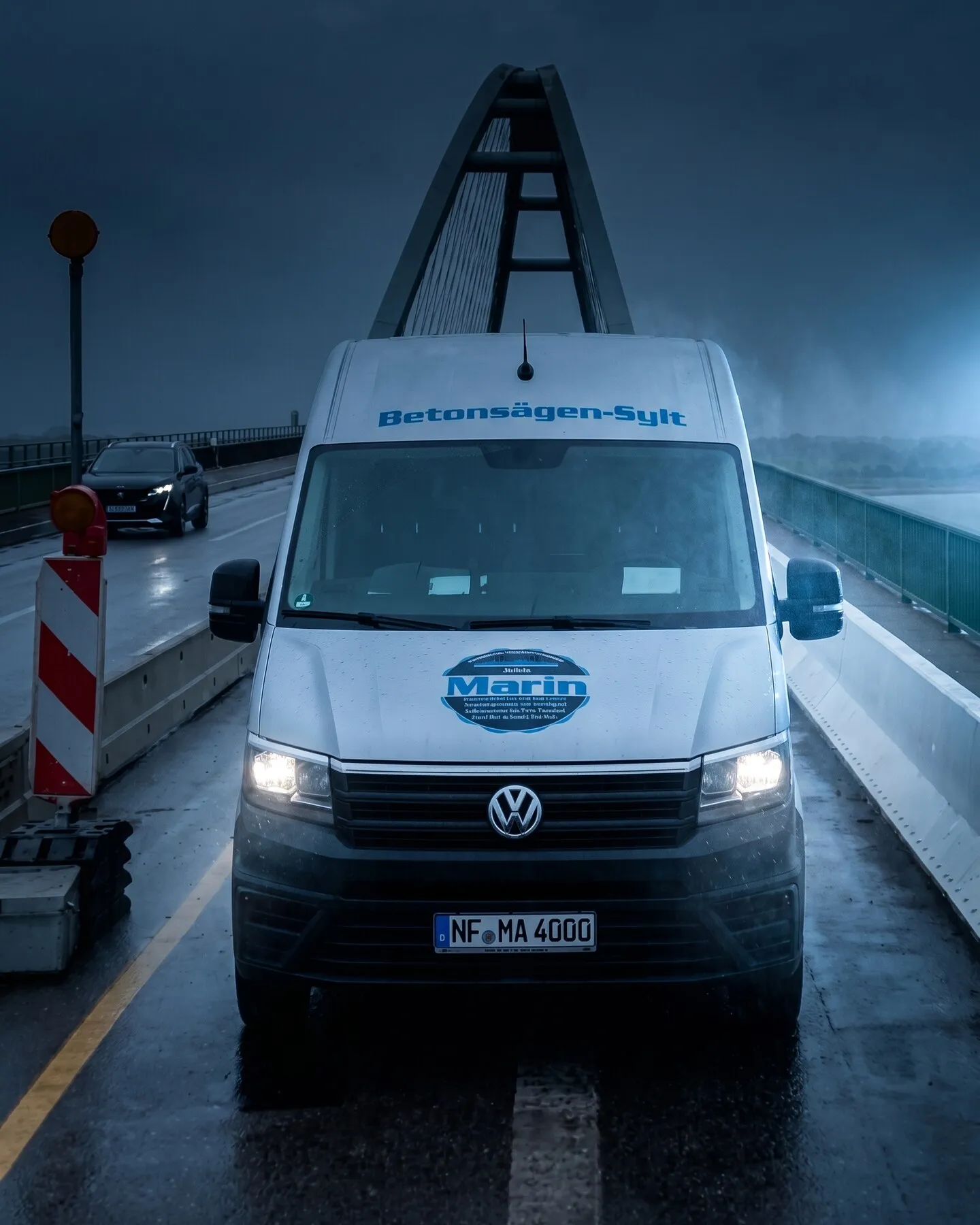 Transporter Betonsägen-Sylt fährt im Regen über eine Brücke